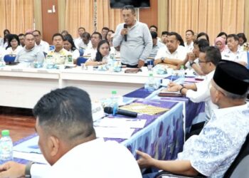 Bupati Simalungun Anton Saragih (pakai peci) melihat Kadis Kesehatan Edwin Simanjuntak saat berbicara dalam rapat kordinasi di Bale Harungguan, Rabu (12/11/2025).(Simantab/ist)